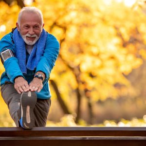 Ein Senior treibt im Herbst Sport.